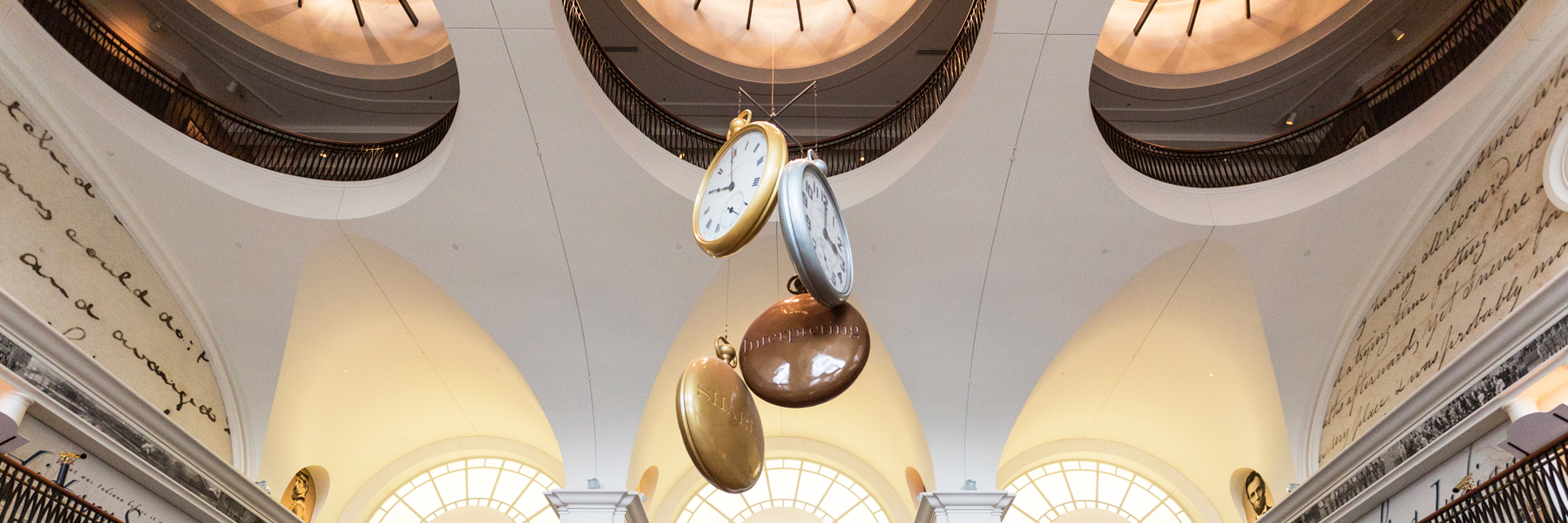 Clocks hanging from a ceiling.