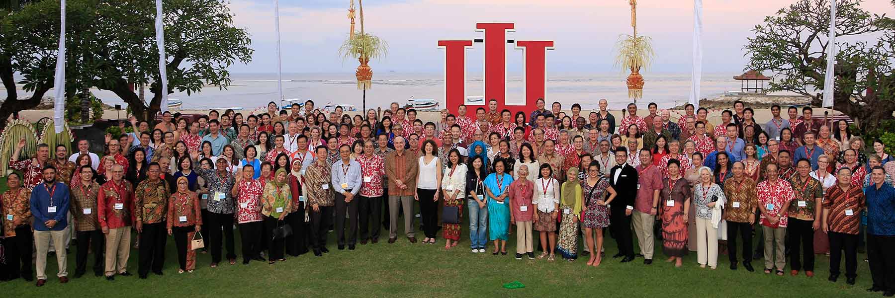 Conference attendees standing outside in front of a giant IU trident.